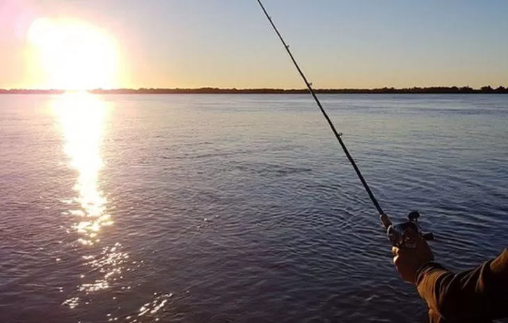 Persona pescando en un río de Paraguay, estilo de vida natural ideal para arquitectura sustentable