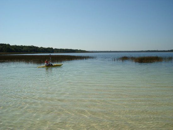 Persona remando en kayak sobre un lago en Paraguay, estilo de vida natural y arquitectura sostenible